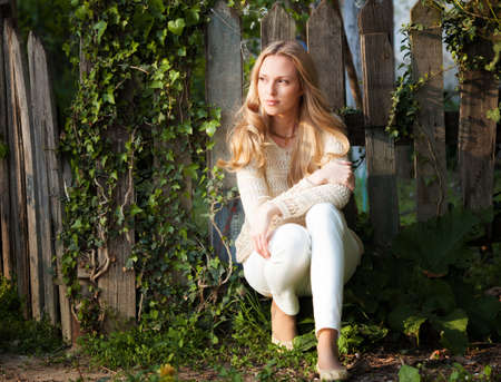Beautiful blond woman portrait near wooden fenceの写真素材