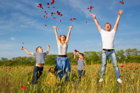 Family of four person playing on the poppy fieldの写真素材