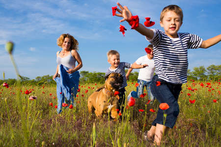 Family of four person playing on the poppy fieldの写真素材