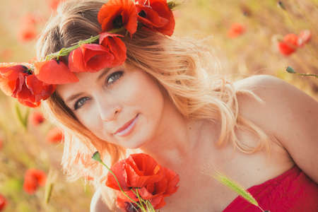 Beautiful young woman on the poppy fieldの写真素材