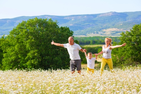 Family of three person on the camomile meadowの写真素材