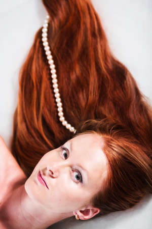 Woman with long red hair isolated on whiteの写真素材
