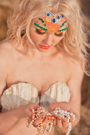 Mermaid portrait with pearls in handの写真素材