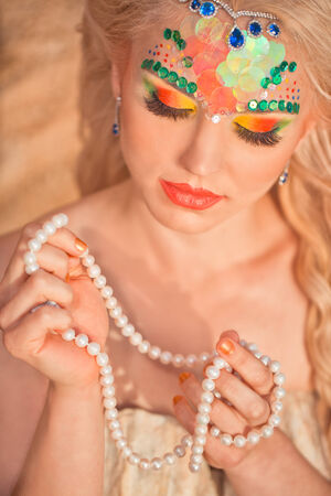 Mermaid portrait with pearls in handの写真素材