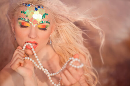 Mermaid portrait with pearls in handの写真素材
