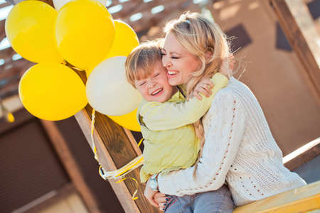 Mother with son playing on the autumn streetの写真素材