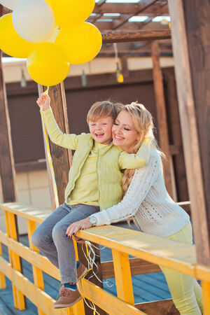 Mother with son playing on the autumn streetの写真素材