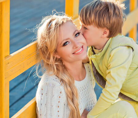 Mother with son playing on the autumn streetの写真素材