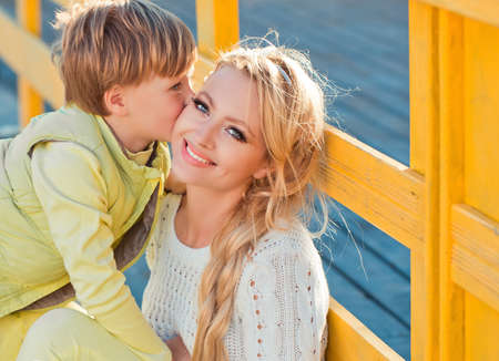 Mother with son playing on the autumn streetの写真素材