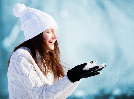 Girl playing with snow in parkの写真素材