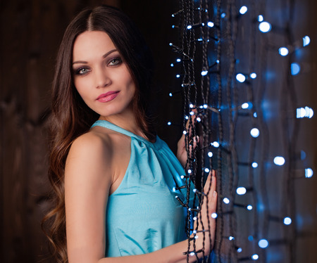 Beautiful girl with long hair portrait near led decorated wallの写真素材