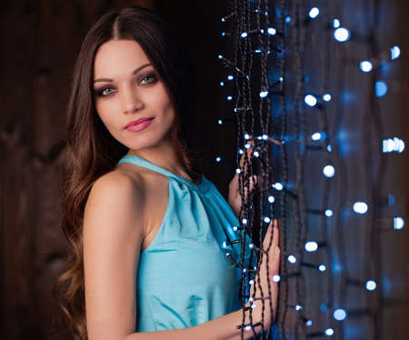 Beautiful girl with long hair portrait near led decorated wallの写真素材