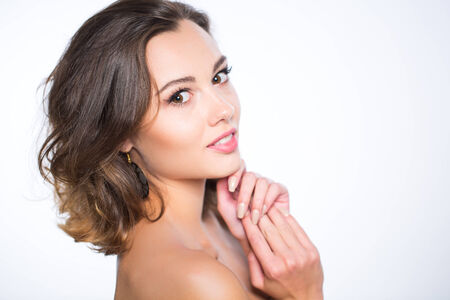 Beautiful face of young adult woman with clean fresh skin - isolated on whiteの写真素材