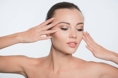 Beautiful face of young adult woman with clean fresh skin - isolated on whiteの写真素材