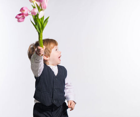 Little boy with bouquet of tulip flowers in handsの写真素材