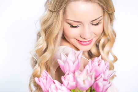 Young beautiful woman portrait with bouquet of tulip flowersの写真素材