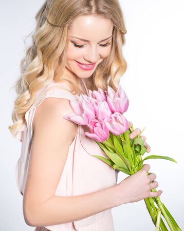 Young beautiful woman portrait with bouquet of tulip flowersの写真素材