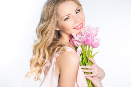 Young beautiful woman portrait with bouquet of tulip flowersの写真素材