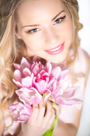 Young beautiful woman portrait with bouquet of tulip flowersの写真素材