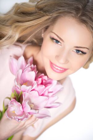 Young beautiful woman portrait with bouquet of tulip flowersの写真素材