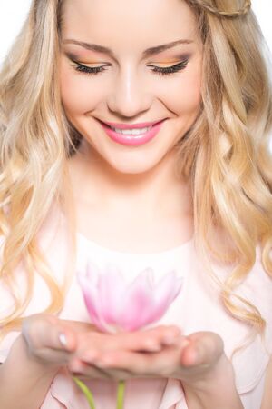 Young beautiful woman portrait with tulip flower in handの写真素材