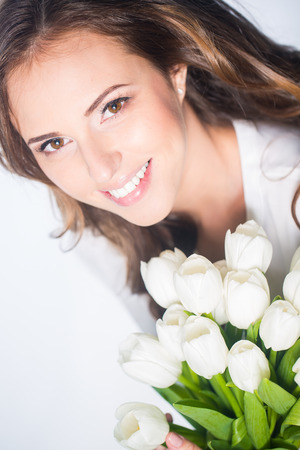 Young beautiful woman studio portrait with tulip flowersの写真素材
