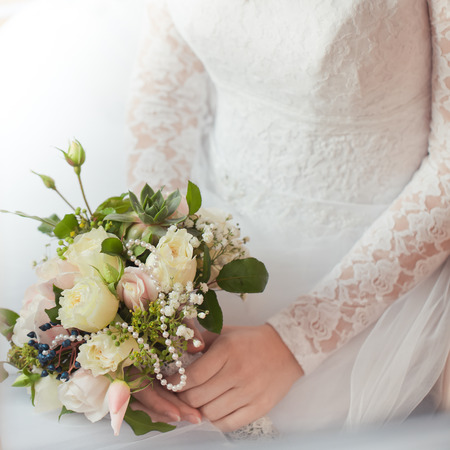 Bride holding bouquet of rose flowers in handsの写真素材