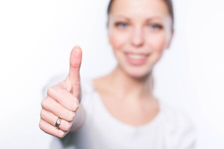 Beautiful young woman showing thumbの写真素材