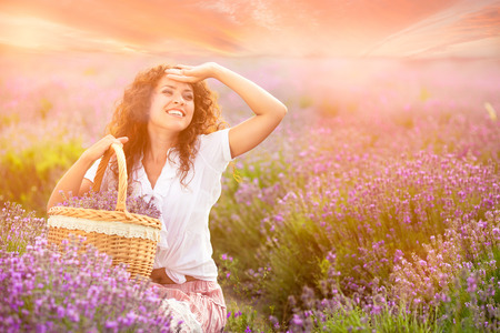 Beautiful young woman harvesting lavender on fieldの写真素材