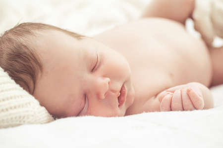 Infant boy sleeping in bedの写真素材