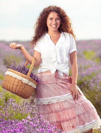 Beautiful young woman harvesting lavender on fieldの写真素材