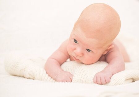 Infant boy laying on the bedの写真素材