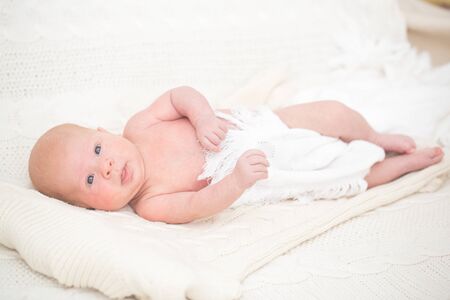 Infant boy laying on the bedの写真素材