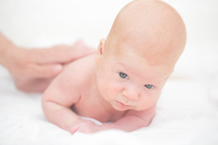Infant boy laying on the bedの写真素材