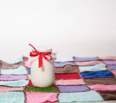 A bank of milk on the carpet of multi-colored piecesの写真素材