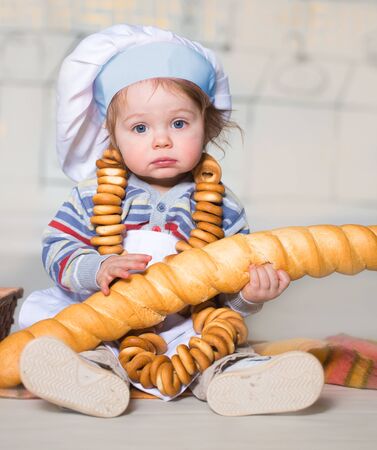 Little boy eating bred in bakeryの写真素材