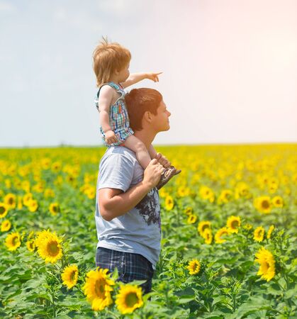Father with son on the sunflower fieldの写真素材