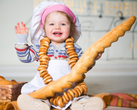Little boy eating bred in bakeryの写真素材