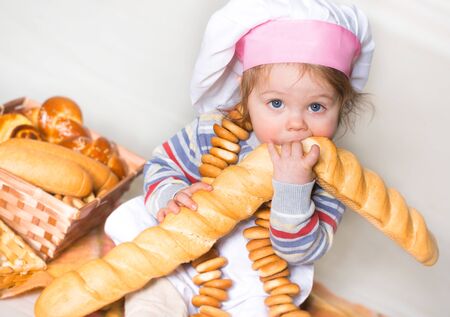 Little boy eating bred in bakeryの写真素材