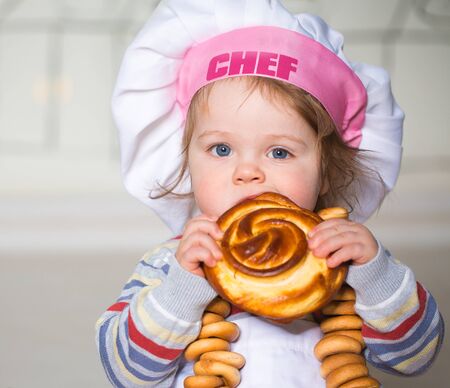 Little boy eating bred in bakeryの写真素材
