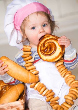 Little boy eating bred in bakeryの写真素材