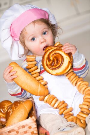 Little boy eating bred in bakeryの写真素材