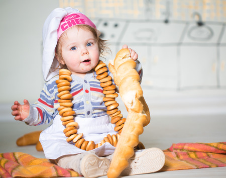 Little boy eating bred in bakeryの写真素材