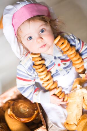 Little boy eating bred in bakeryの写真素材