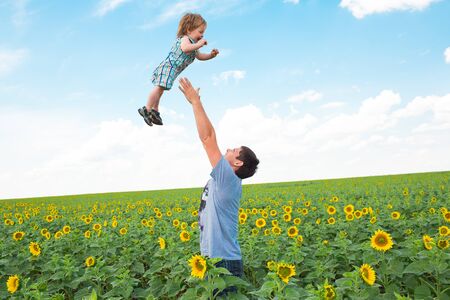 Father with son on the sunflower fieldの写真素材