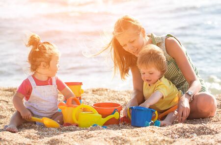Mother playing with children on the beachの写真素材