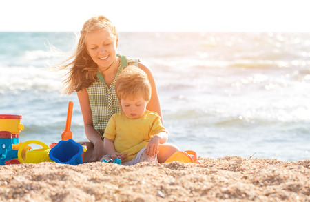 Mother playing with child on the beachの写真素材