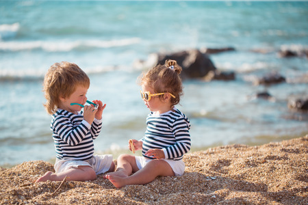 Little boy and girl playing on the beachの写真素材