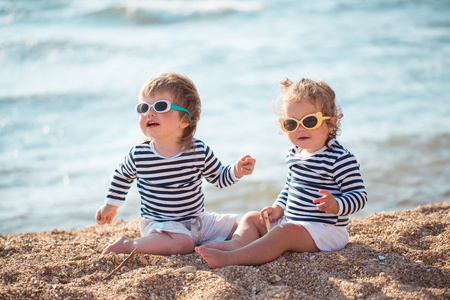 Little boy and girl playing on the beachの写真素材