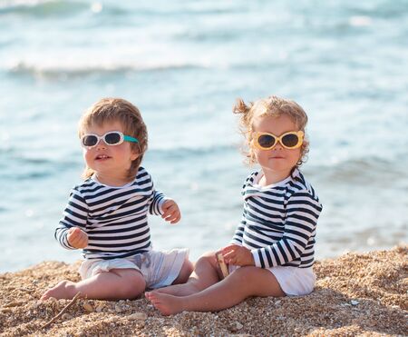 Little boy and girl playing on the beachの写真素材